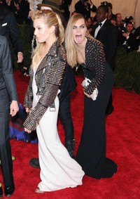 Masih di acara Costume Institute Gala, New York, model Cara Delevingne menyelinap di belakang aktris Sienna Miller sambil menjulurkan lidah. Keduanya pun tampil kompak dengan gaya rambut belah pinggir dan jaket kulit berpaku.