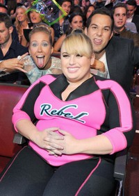 Komedian Rebel Wilson terlihat sedang pamer senyum sumringah kepada fotografer di acara Teen Choice Awards di Gibson Amphitheatre, California, Minggu (11/08/2013). Momen ini digunakan oleh aktor Anna Camp dan Skylar Astin untuk mengusilinya.
