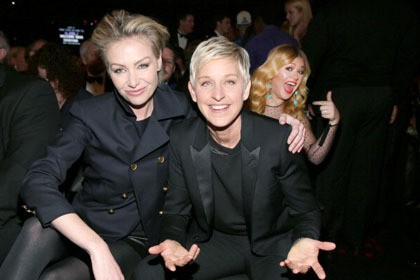 Pasangan Portia de Rossi dan Ellen DeGeneres terlihat mesra saat difoto bersama di acara Grammy Awards ke-55 di Staples Center, California. Di belakangnya muncul sosok wanita girang yang tak lain adalah penyanyi jebolan American Idol, Kelly Clarkson.