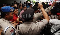 Petugas berusaha menenangkan massa.