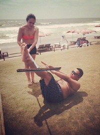 Ibu tiga anak itu juga meng-upload foto dirinya mengenakan bra berwarna terang dan hot pants hitam di pinggir pantai. (Instagram)