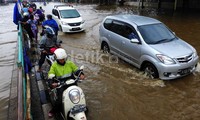 Pengendara melintasi banjir di Jalan KH Abdullah Syafei, Tebet, Jakarta Selatan, Jumat (24/1/2014).