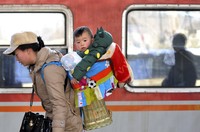 Seorang warga China membawa anaknya mudik dengan kereta api di Nanjing, Provinsi Jiangsu, 22 Januari 2014. REUTERS/Stringer.