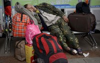 Seorang pemudik tertidur di saat menunggu kereta. REUTERS/Stringer.
