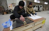 Proses pengerjaan karya seni ini dimulai dengan merekatkan kertas dengan lem. REUTERS / Jason Lee.