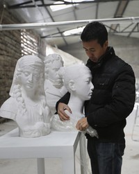 Li Hongbo sedang membungkus karyanya dengan plastik pembungkus. REUTERS / Jason Lee.     