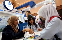 Sejumlah siswa, tengah mengamati teknologi Virtual Kampus 3D, berbasis game yang dipandu oleh seorang mahasiswi UMN, di pameran IIET Expo 2014.