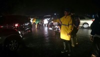 Wali kota Vicky mengenakan jas hujan berwarna kuning saat mengatur lalu lintas. (dok. KNPI)