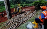 Alat berat dikerahkan untuk memadatkan jalan yang amblas.