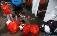 Warga mengantre saat menyetorkan baju kotornya untuk dicuci.