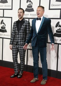 Ryan Lewis tampil mengenakan setelan bermotif houndstooth sementara Macklemor tampil mengenakan setelan tuxedo berwarna biru. REUTERS/Danny Moloshok.     