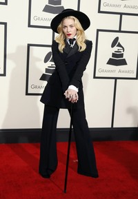 Tak tampil anggun dengan gaun, Madonna memilih untuk tampil maskulin dengan tuxedo hitam dari Ralph Lauren. REUTERS/Danny Moloshok.