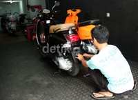 Seorang mekanik memperbaiki Vespa. (SHD).