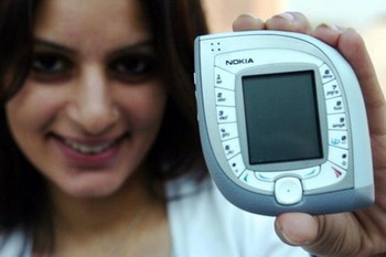 Seorang model memamerkan Nokia 7600 di New Delhi tahun 2004. Ponsel ini punya kapabilitas 3G, kamera, pemutar musik dan dikemas dalam desain menawan.