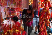 Seorang warga memilih pernak-pernik Imlek.