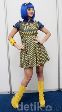 Jenita Janet tampil dengan wig biru, dress polkadot biru-kuning, dan sepatu boots kuning yang ngejreng. Gus Mun/detikHOT.