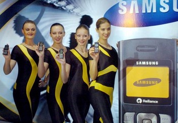 Beberapa SPG memamerkan ponsel CDMA Samsung dengan fitur sederhana.
