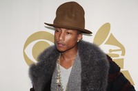 Rapper Pharrell Williams tampil percaya diri lewat topi oversized dari Vivienne Westwood dipadu dengan cardigan abu-abu serta jaket dengan aksen bulu. REUTERS/Jonathan Alcorn.