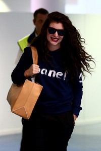 Lorde tak henti-hentinya tersenyum saat tiba di Selandia Baru. Phil Walter/Getty Images.