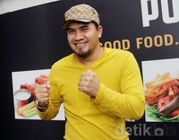 Ia memadukan gayanya dengan topi coklat. Gus Mun/detikHOT.