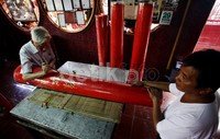 Terlihat sebuah lilin raksasa yang sedang di beri tulisan berbahasa cina oleh seorang pengurus vihara.