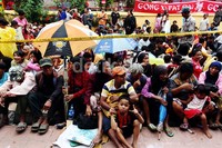 Mereka duduk di pelataran berharap mendapatkan angpau dari pengunjung vihara.