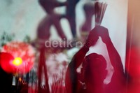 Seorang warga menyalakan dupa dan berdoa.