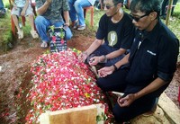 Keluarga dan sahabat berdoa di depan makam Murry.