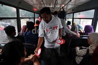 Para aktivis KIPP juga membagikan stiker kepada penumpang angkutan umum.