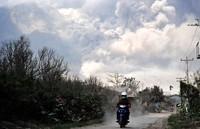 Seorang warga memacu motornya untuk menghindari awan panas Gunung Sinabung. AFP/Adek Berry.