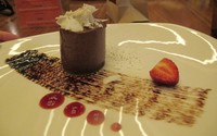 Cioccolato Broadway con coulis di mango, mousse cokelat berbentuk silindris diselingi lapisan saus mangga.