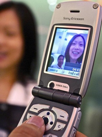 Seorang model mencoba fitur 3G di ponsel  Z1010 di ajang ComunicAsia 2004 di Singapura.     