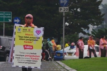 Hujan Tak Halangi Aksi Bagi-bagi Bunga di Hari Kanker Sedunia