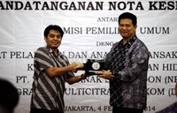 Pimpinan Redaksi detikcom Arifin Asydhad (kiri) menyerahkan cinderamata kepada Ketua KPU Husni Kamil Manik (kanan) seusai penandatanganan kerjasama.