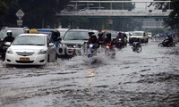 Para pengendara menerobos banjir di Jalan Merdeka Timur.