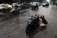 Sebuah sepeda motor mogok akibat menerobos banjir.