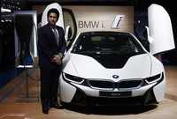 Pemain criket yang sudah pensiun Sachin Tendulkar berpose dengan mobil listrik BMW i8 di Indian Auto Expo. Reuters/Adnan Abidi.