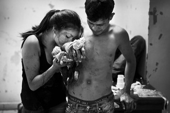 Seorang wanita dan pacarnya yang terluka, menggambarkan maraknya kekerasan di Amerika Latin. (kredit foto: Javier Arcenillas)