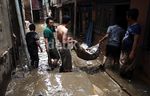 Membersihkan Lumpur dan Sampah Sisa Banjir