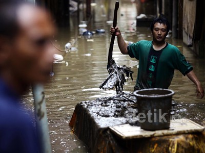 Membersihkan Lumpur dan Sampah Sisa Banjir