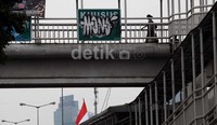 Warga melintas di atas jembatan penyebrangan orang di pasar rumput, Jakarta Selatan, Jumat (7/2/2014).