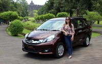 Seorang wanita berpose dengan Honda Mobilio. Saat dikendarai Mobilio ini cukup responsif. Baik mobil matik maupun manualnya.