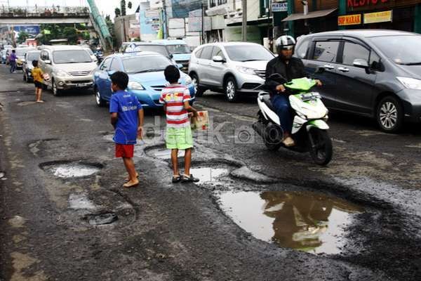 Hantam Jalan Berlubang, Anggota Polisi Terjatuh dari Motor