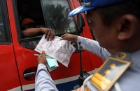 Terlihat seorang aparat Polisi sedang menanyakan kelengkapan surat-surat seorang sopir metromini.