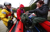 Warga Wraysbury Pam Samuel dan anak perempuannya Jo Samuel Blackstock saat diselamatkan oleh tim penyelamat dari banjir yang mengepung rumah mereka. REUTERS/Eddie Keogh.
