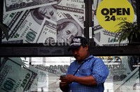 Seorang warga menghitung uang di depan Money Changer, Sabang, Jakarta Pusat. Menjelang penutupan perdagangan Rabu (12/2/2014), rupiah masih terpantau menguat terhadap dolar AS. Penguatan rupiah terjadi saat dolar AS ditransaksikan melemah terhadap sebagian besar mata uang di Asia Pasifik.