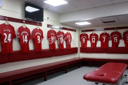 Ruang ganti pemain di Anfield yang sama sekali tidak punya kesan mewah. Ruang ini bahkan bisa dianggap sederhana dengan hanya berisi bangku panjang tempat pemain duduk, tiga meja pijat serta papan tulis dari kertas.