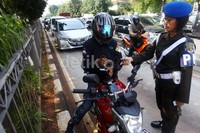 Seorang anggota Polisi Militer meminta pengendara menunjukkan kelengkapan surat kendaraan.