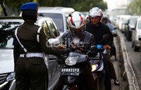 Seorang anggota Polisi Militer memeriksa kelengkapan surat kendaraan.