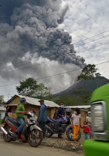 Para warga melihat letusan gunung Sinabung di Sumatra Utara pada September 2013. (kredit foto: getty images)
